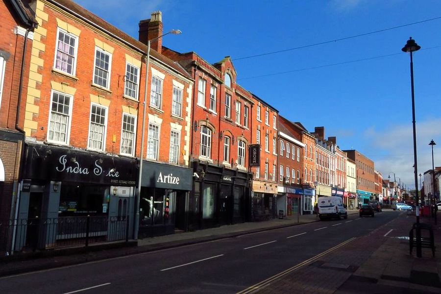 Bromsgrove High Street on a sunny day, lined with red-brick Georgian buildings and shops