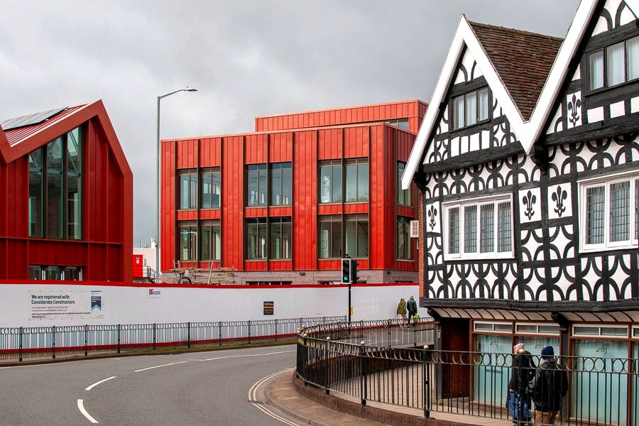 The new red Nailers Yard buildings beside a black-and-white Tudor building at the end of Bromsgrove High Street